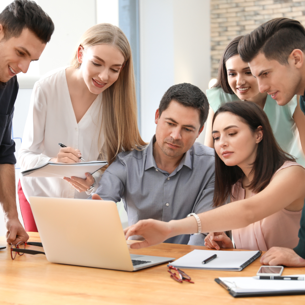 6 people looking at one laptop
