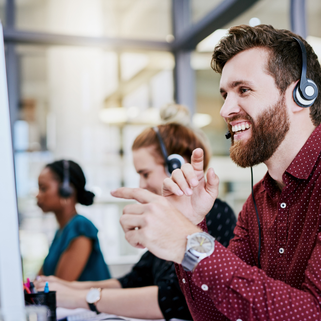 Three people of diverse skin tones smiling, wearing headphones, and engaging in a video call or virtual meeting.