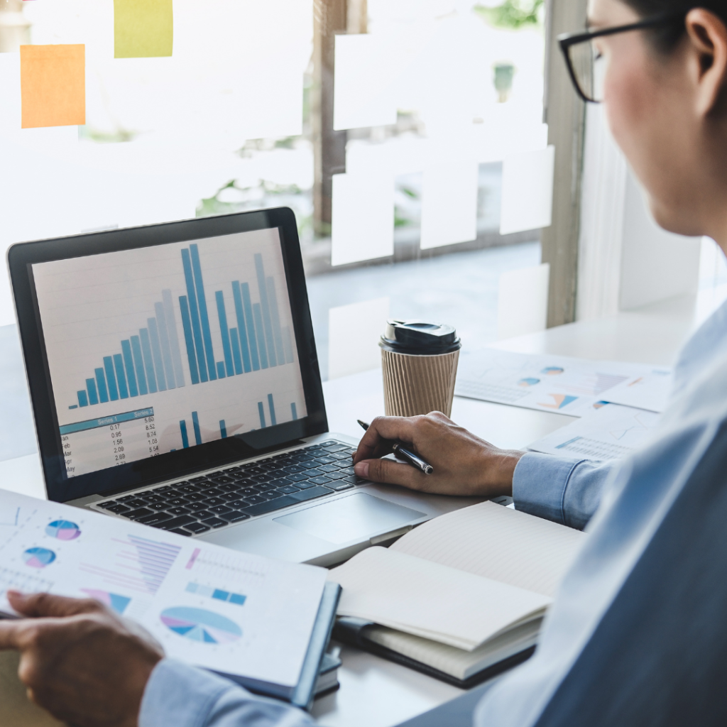 A person viewing analytics and data charts on a laptop screen